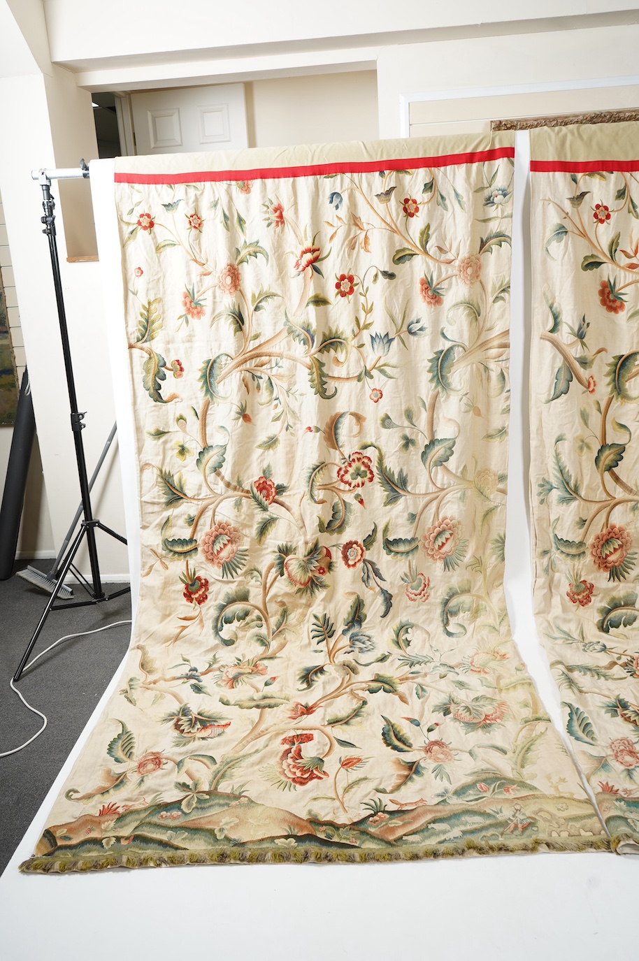 Six 20th century crewel work ‘Tree of Life’ cream linen curtains. Worked at the base in coloured wools depicting a pastoral scene of a shepherd playing a flute amongst sheep, deer, squirrels and flowers with a dog chasin